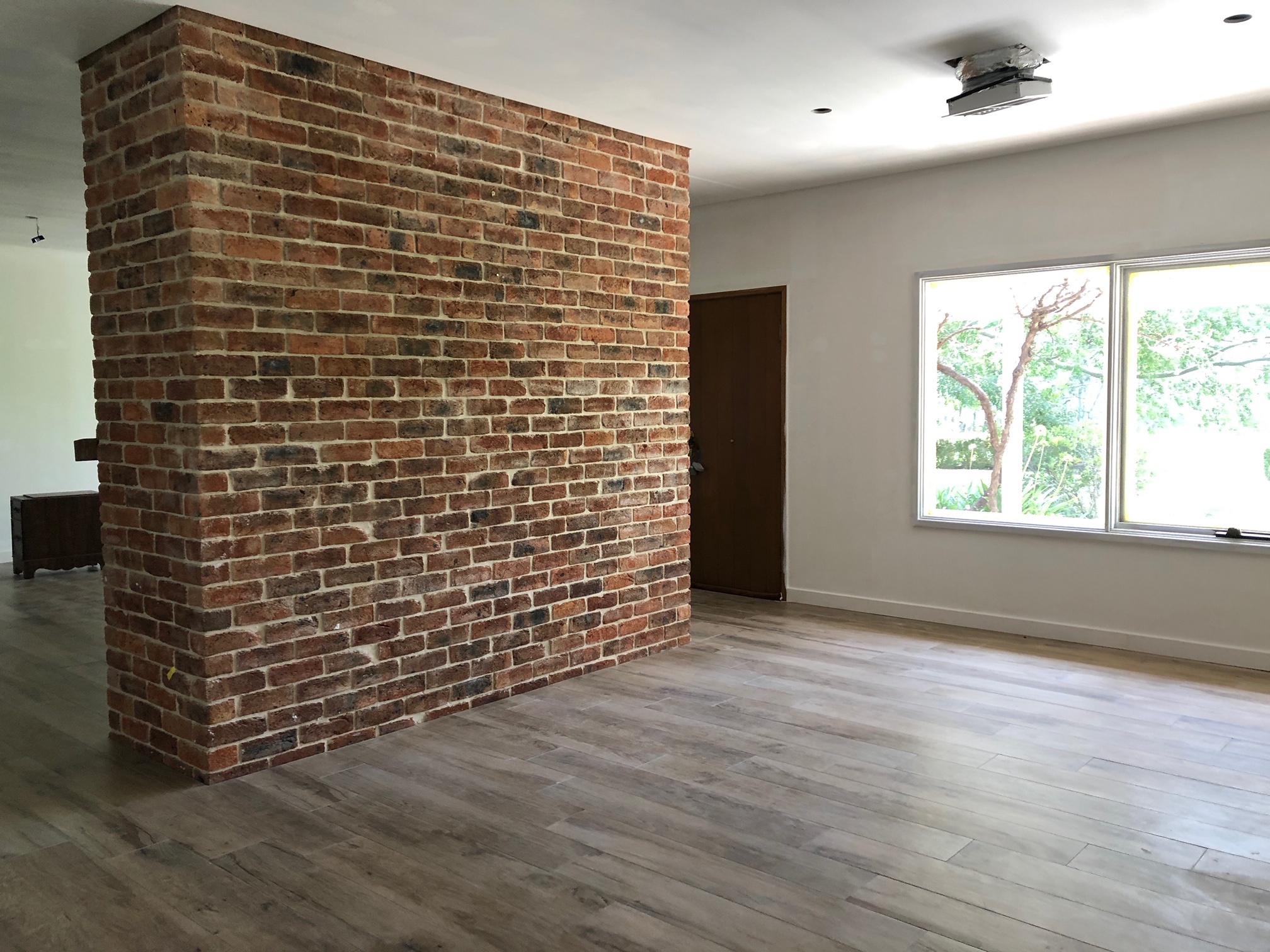 Hunter Plank undertile natural wooden floor heating with large brick fireplace